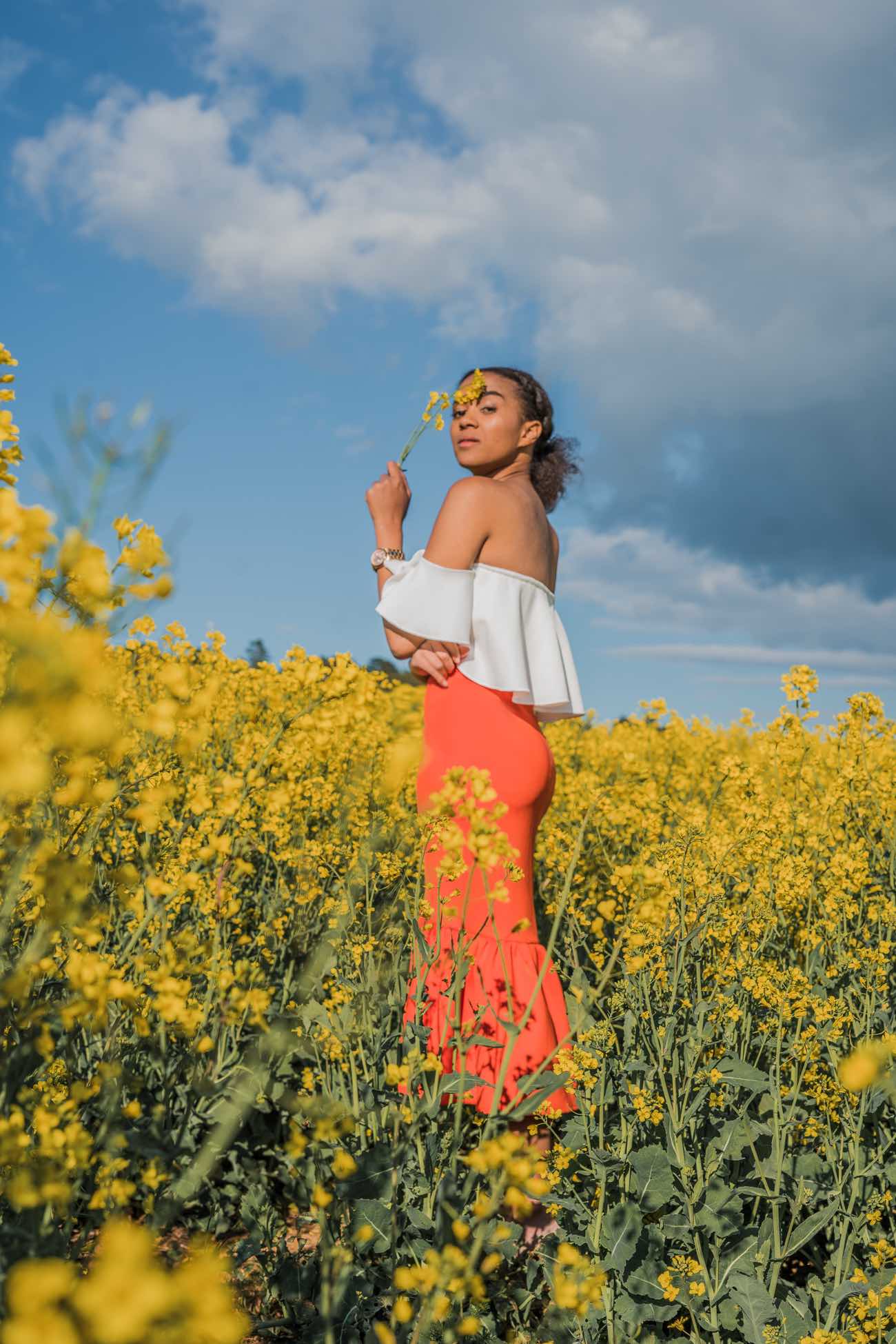 Girl smiling standing in a flower field in summer