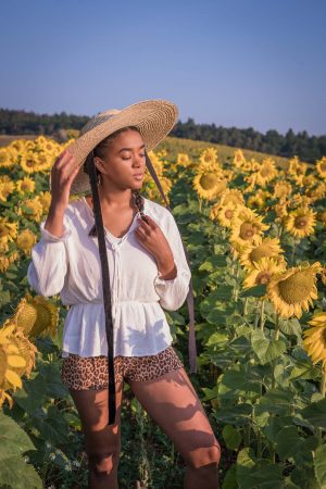 Black Fashion Blogger in a Sunflower Field wearing summer hats