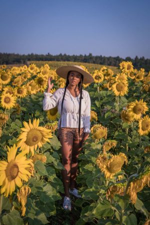 Black Fashion Blogger in a Sunflower Field wearing summer hats