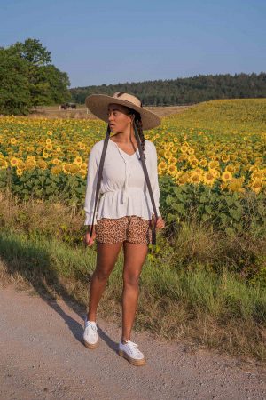 Photoshooting in a sunflower field, pictures in a flower field, straw hat in summer